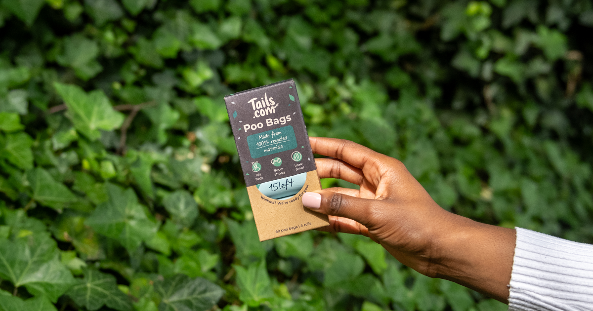 Hand holding new tails.com poo bags pack up outdoors, made from recycled materials